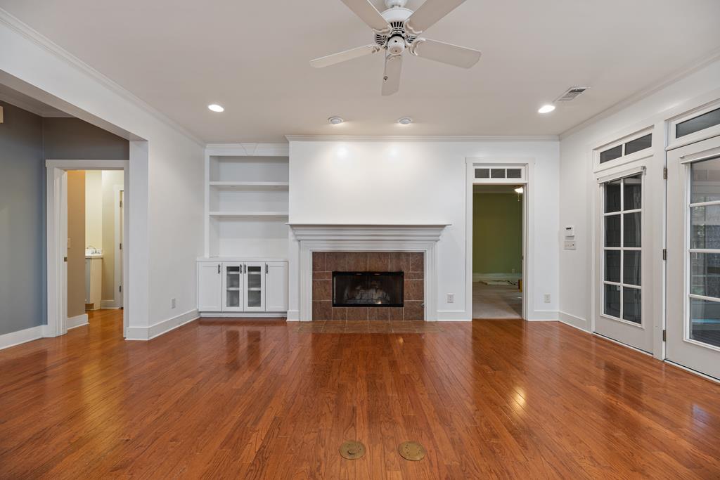 142 Maple Trace Pine Mountain, GA 31822 - Photo 11 of 61 a view of an empty room with wooden floor fireplace and a window