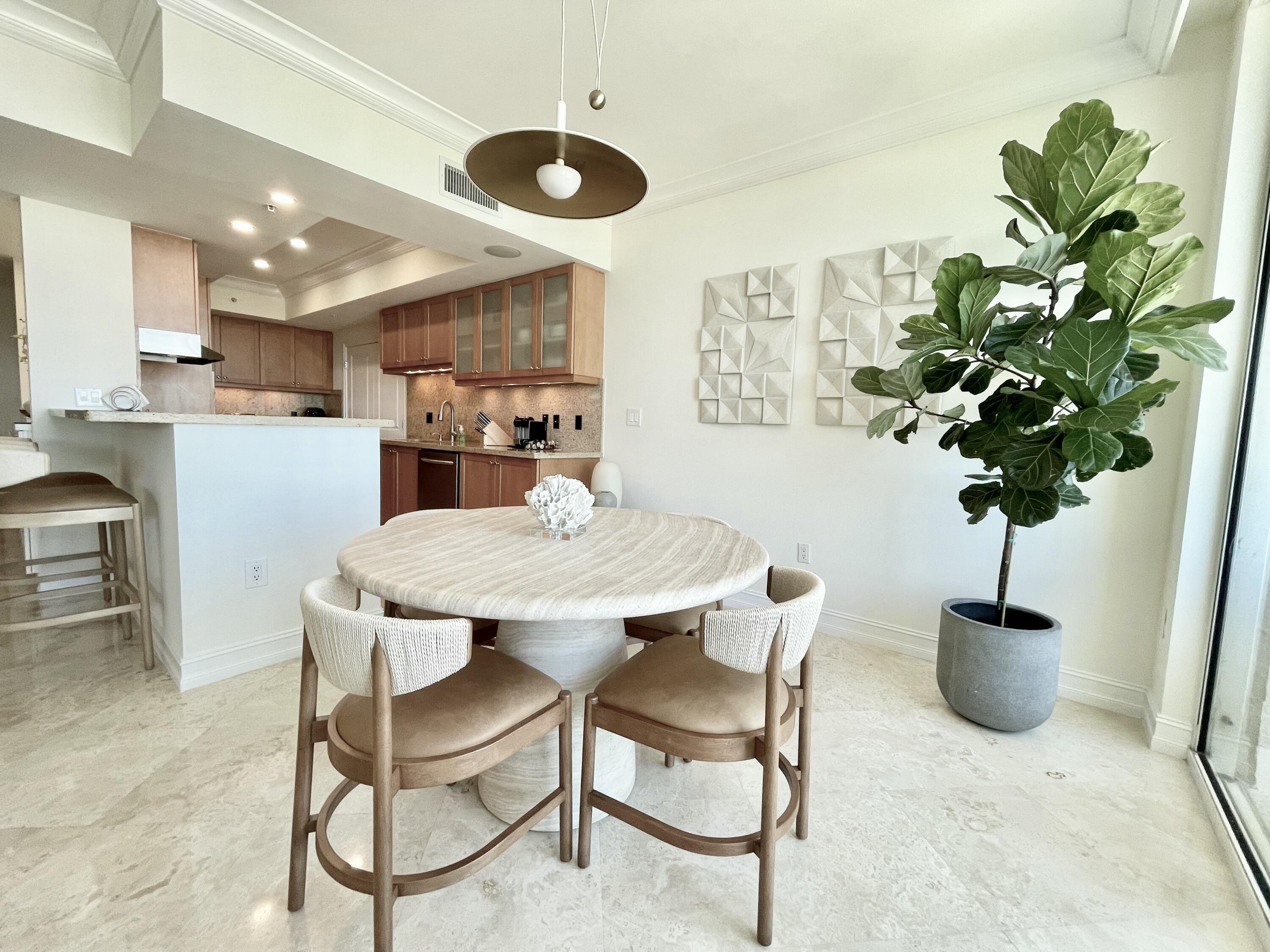 99 Southeast Mizner Boulevard, Unit PH5 Boca Raton, FL 33432 - Photo 10 of 48 a view of a dining room with furniture and a potted plant