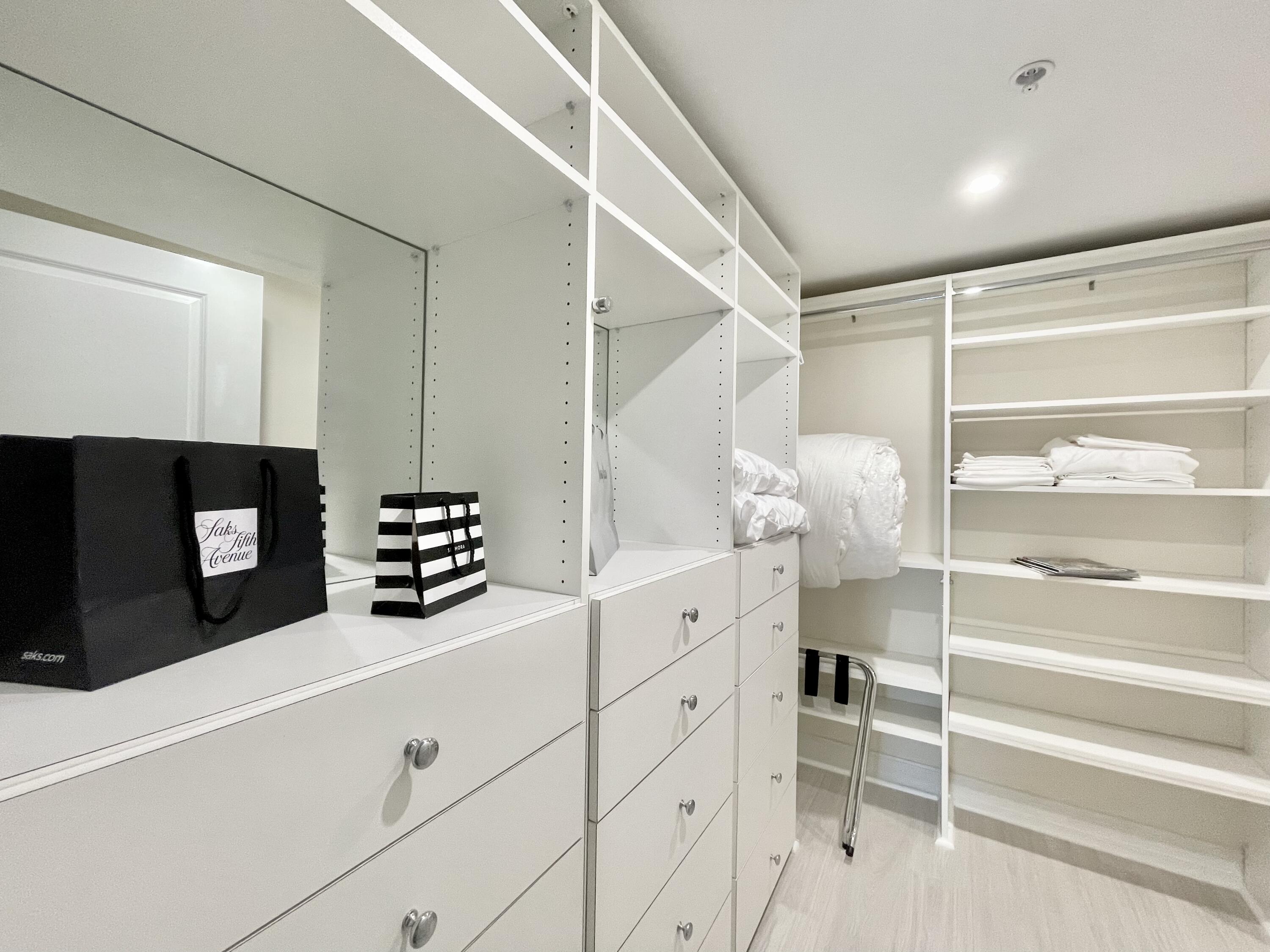 99 Southeast Mizner Boulevard, Unit PH5 Boca Raton, FL 33432 - Photo 14 of 48 a room with white cabinets and flat screen tv