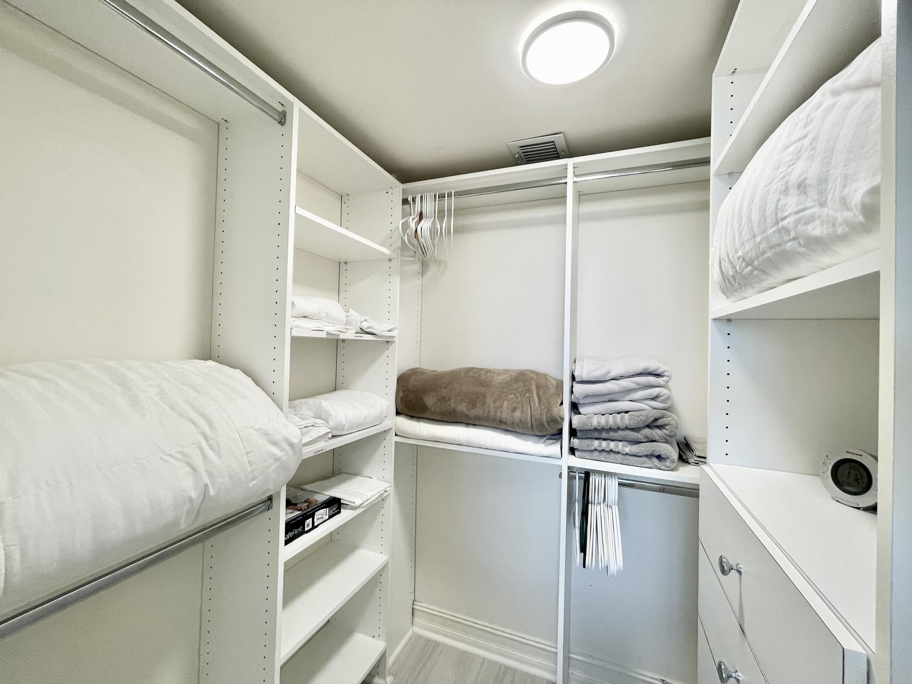 99 Southeast Mizner Boulevard, Unit PH5 Boca Raton, FL 33432 - Photo 27 of 48 a room with a closet and white wooden cabinets