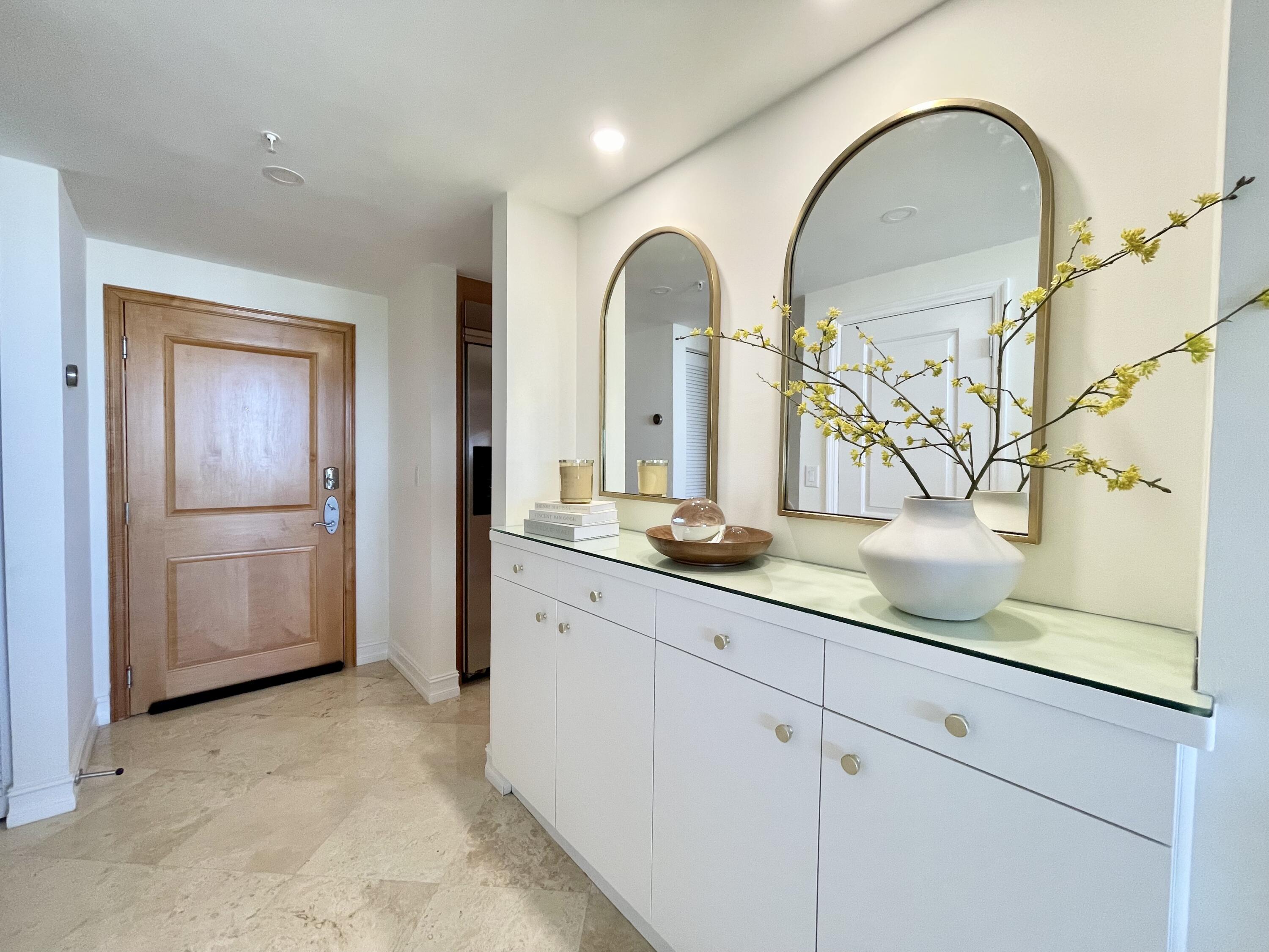 99 Southeast Mizner Boulevard, Unit PH5 Boca Raton, FL 33432 - Photo 29 of 48 a bathroom with a granite countertop sink a potted plant and a mirror
