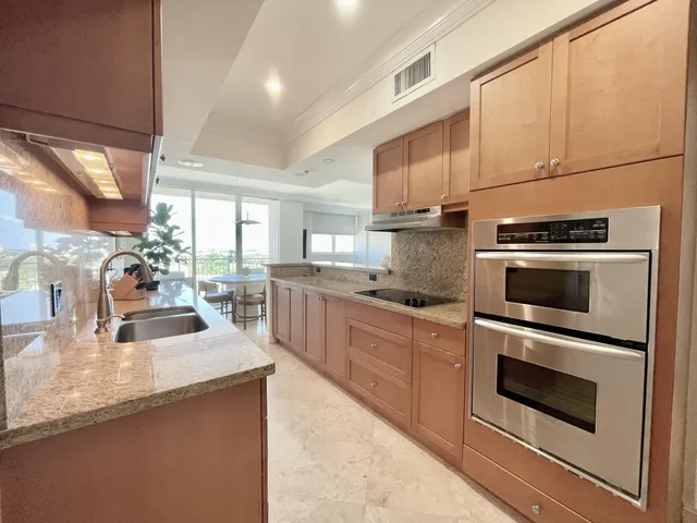 a kitchen with stainless steel appliances granite countertop a sink a stove and a microwave oven with cabinets