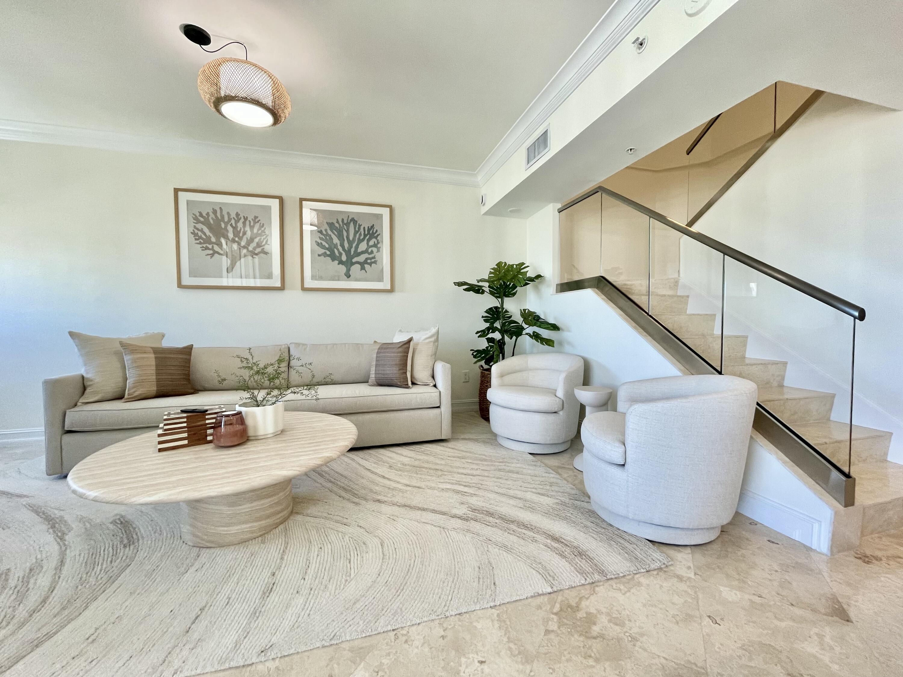 99 Southeast Mizner Boulevard, Unit PH5 Boca Raton, FL 33432 - Photo 5 of 48 a living room with furniture and a potted plant