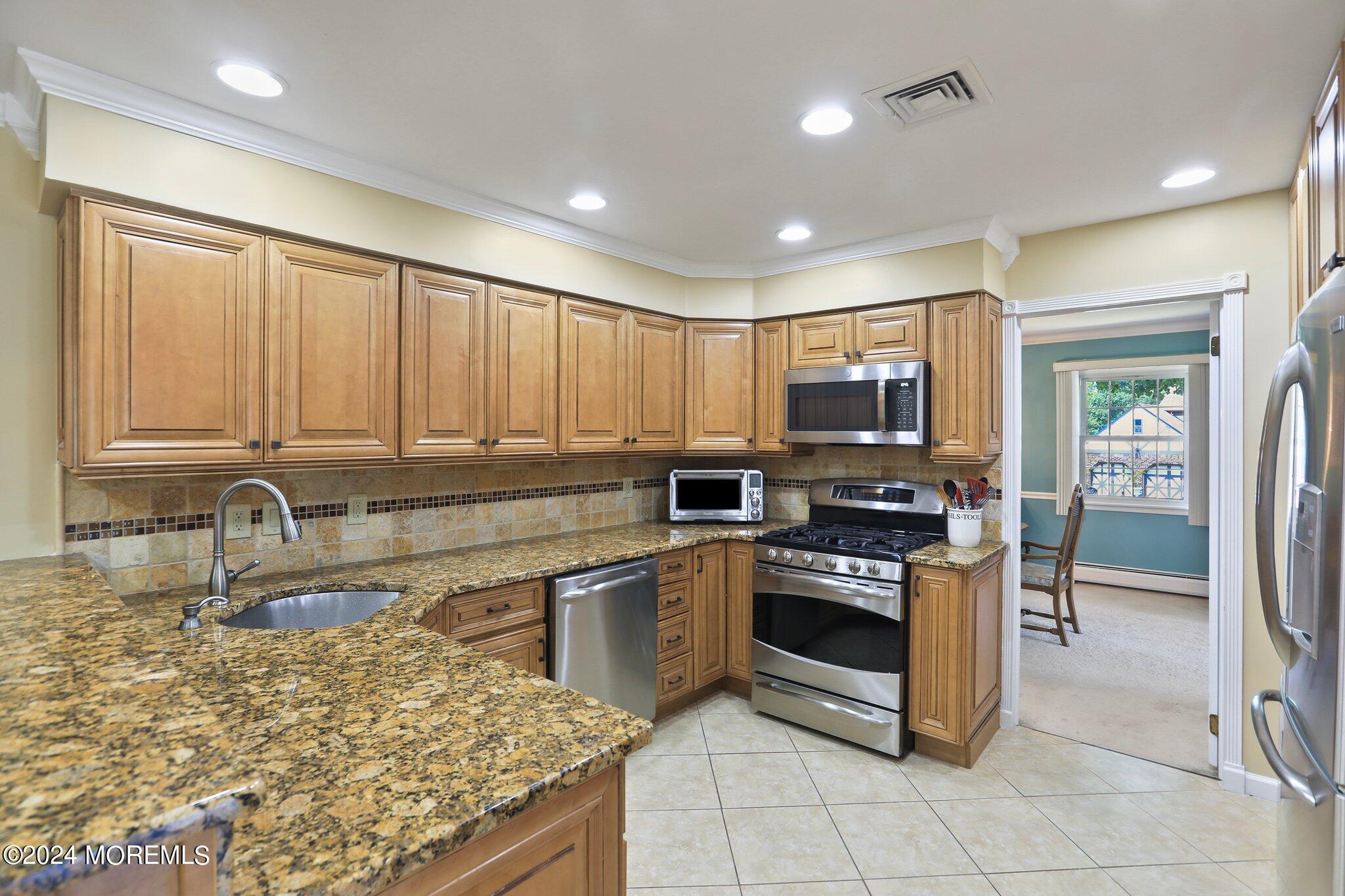 2 Cedar Court Marlboro, NJ 07746 - Photo 15 of 46 a kitchen with stainless steel appliances granite countertop a stove sink and cabinets