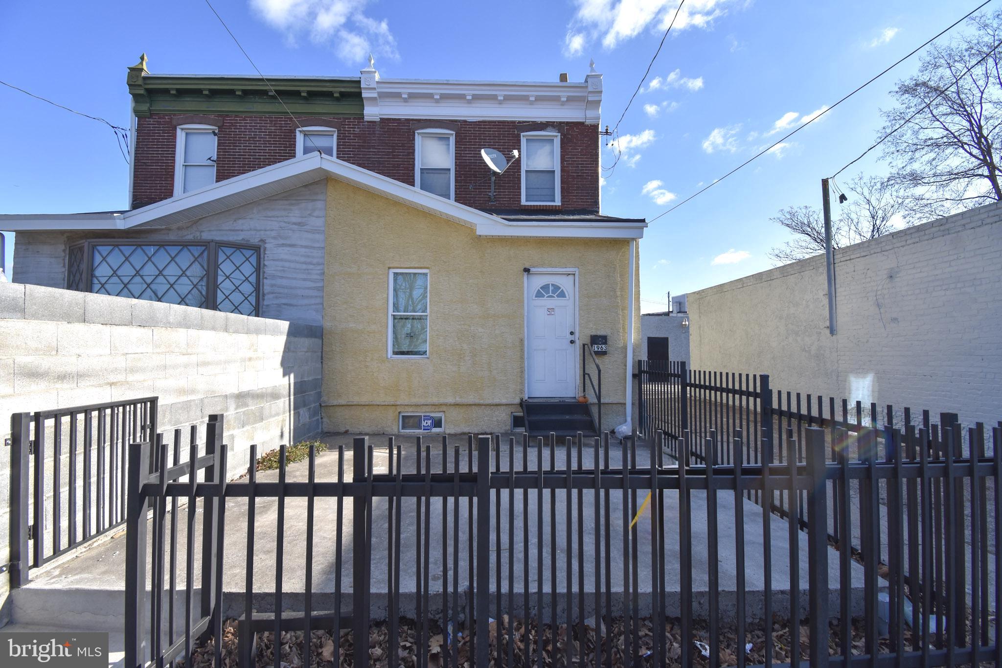 1963 Wakeling Street Philadelphia, PA 19124 - Photo 1 of 18 a view of a brick house with wooden fence