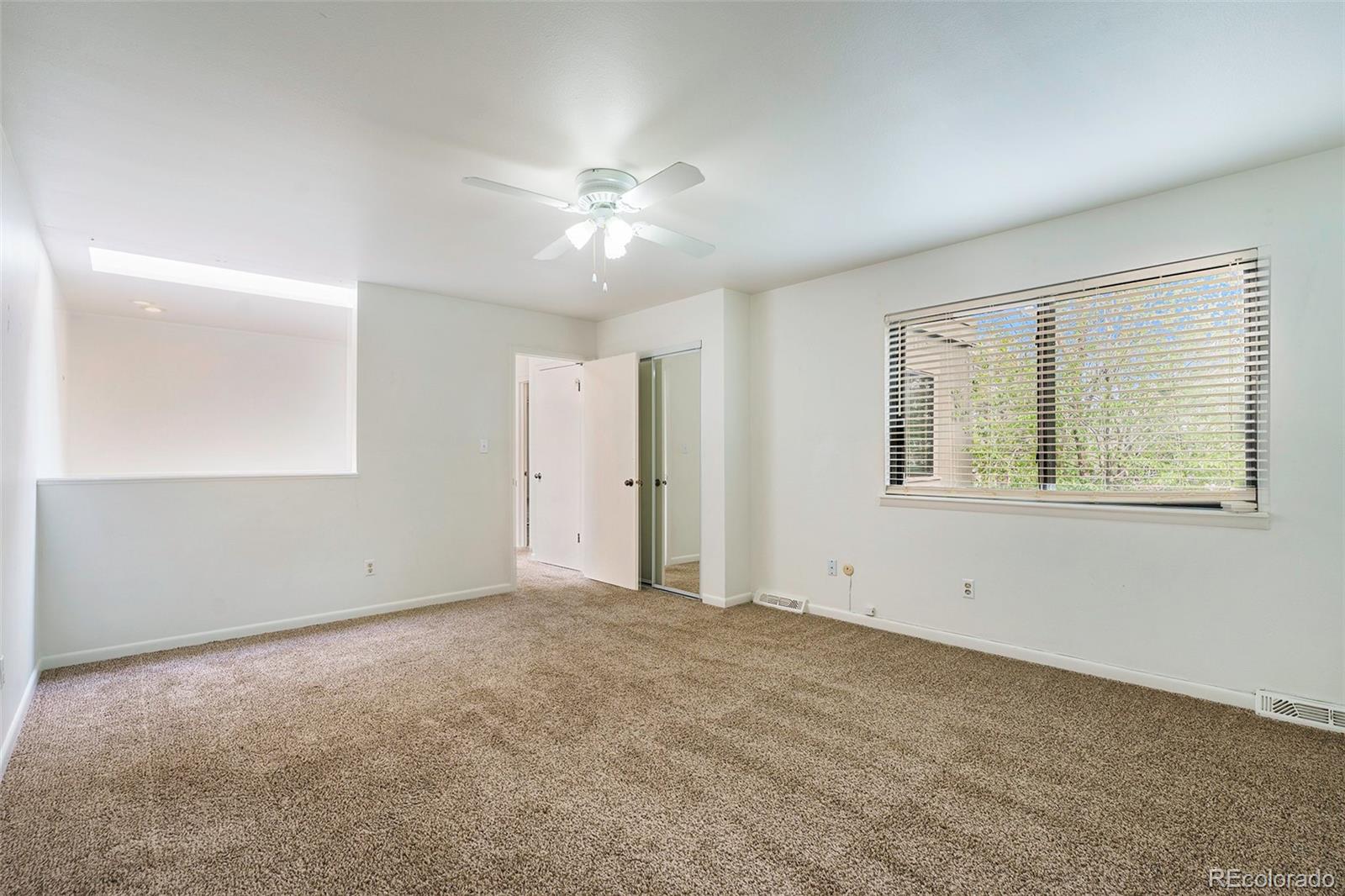 1233 South Yosemite Way, Unit 76 Denver, CO 80247 - Photo 13 of 20 an empty room with windows and fan