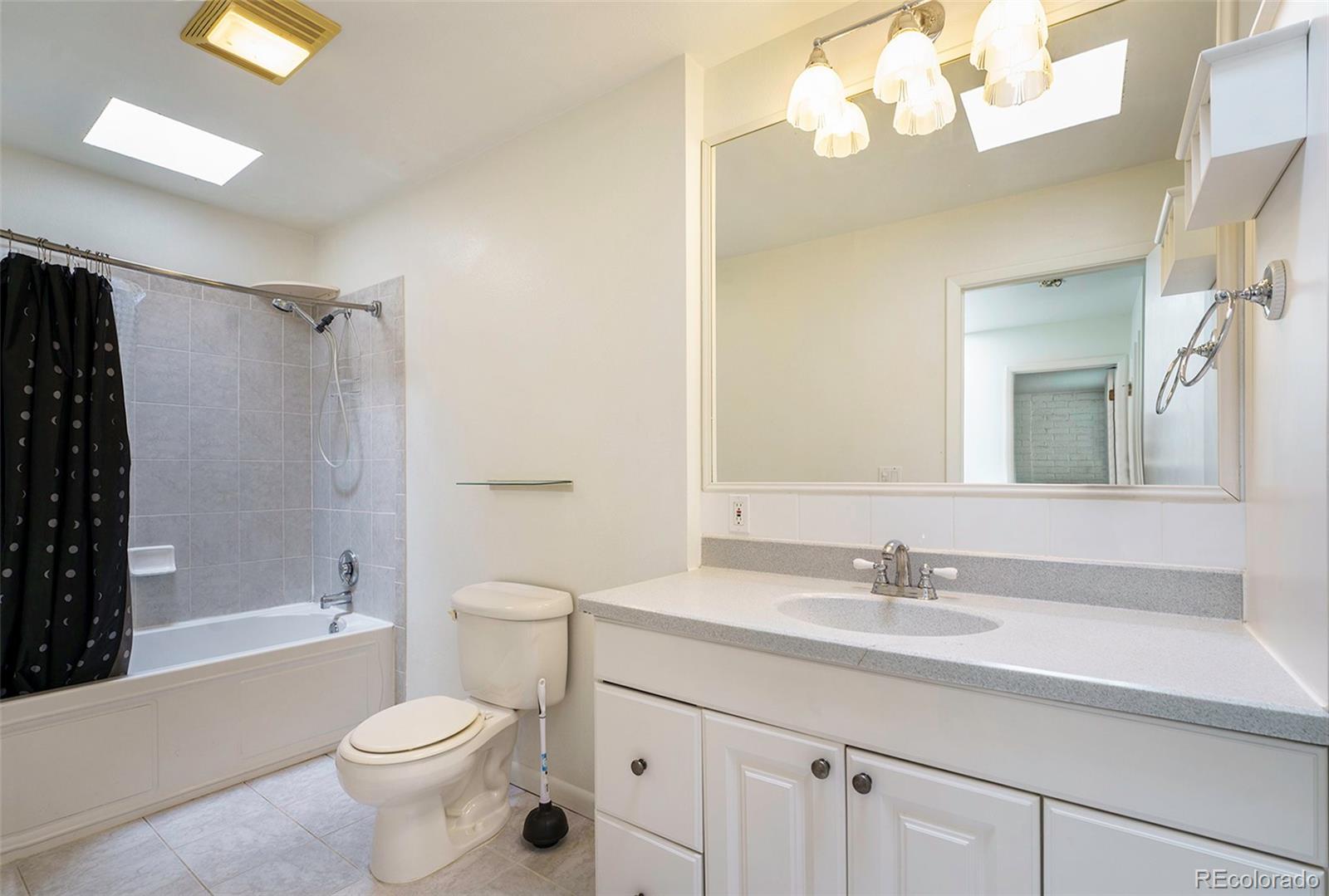 1233 South Yosemite Way, Unit 76 Denver, CO 80247 - Photo 17 of 20 a bathroom with a sink a toilet and shower