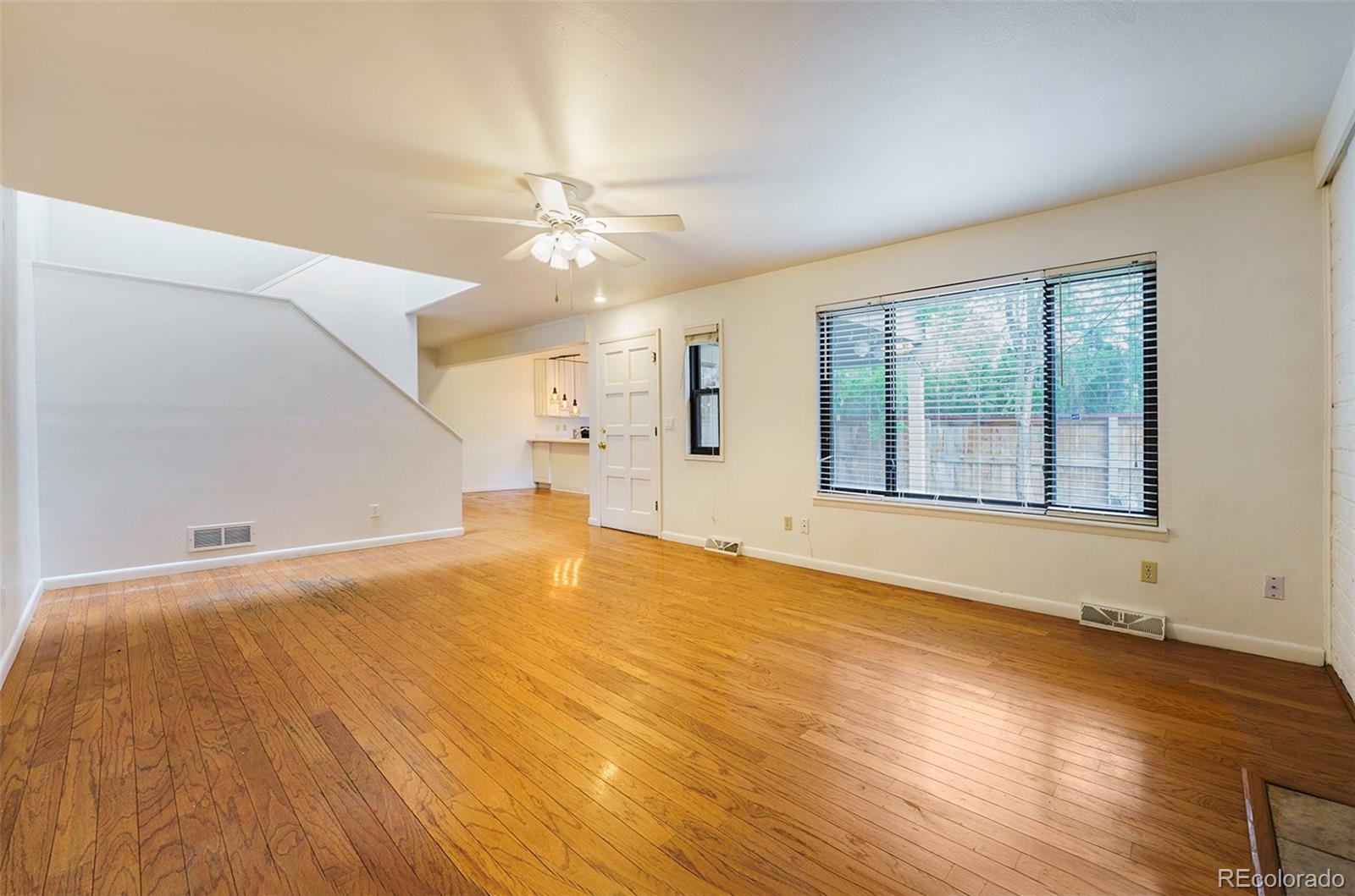 1233 South Yosemite Way, Unit 76 Denver, CO 80247 - Photo 4 of 20 a view of an empty room with a window and wooden floor