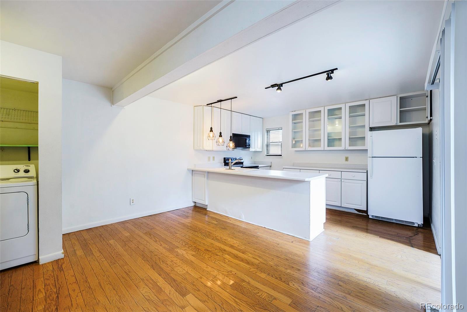 1233 South Yosemite Way, Unit 76 Denver, CO 80247 - Photo 5 of 20 a kitchen with a refrigerator sink and cabinets
