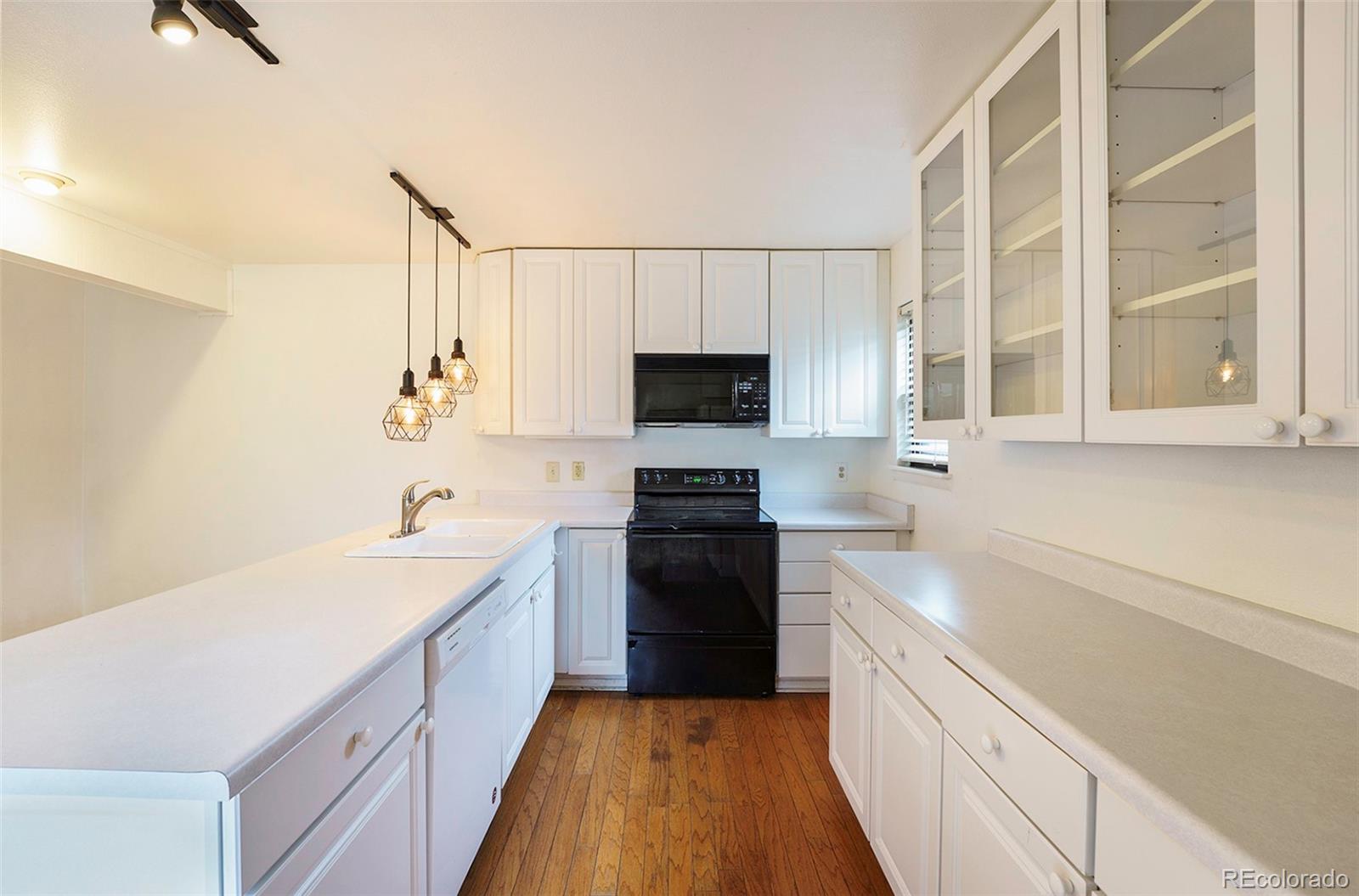 1233 South Yosemite Way, Unit 76 Denver, CO 80247 - Photo 8 of 20 a kitchen with a sink stove and microwave