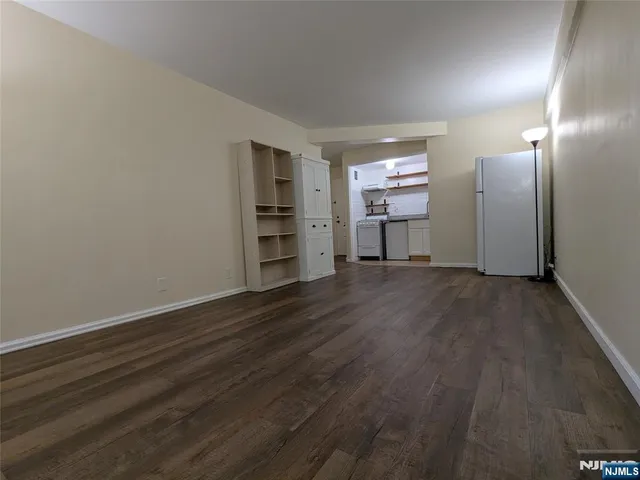a view of a kitchen with wooden floor and a refrigerator