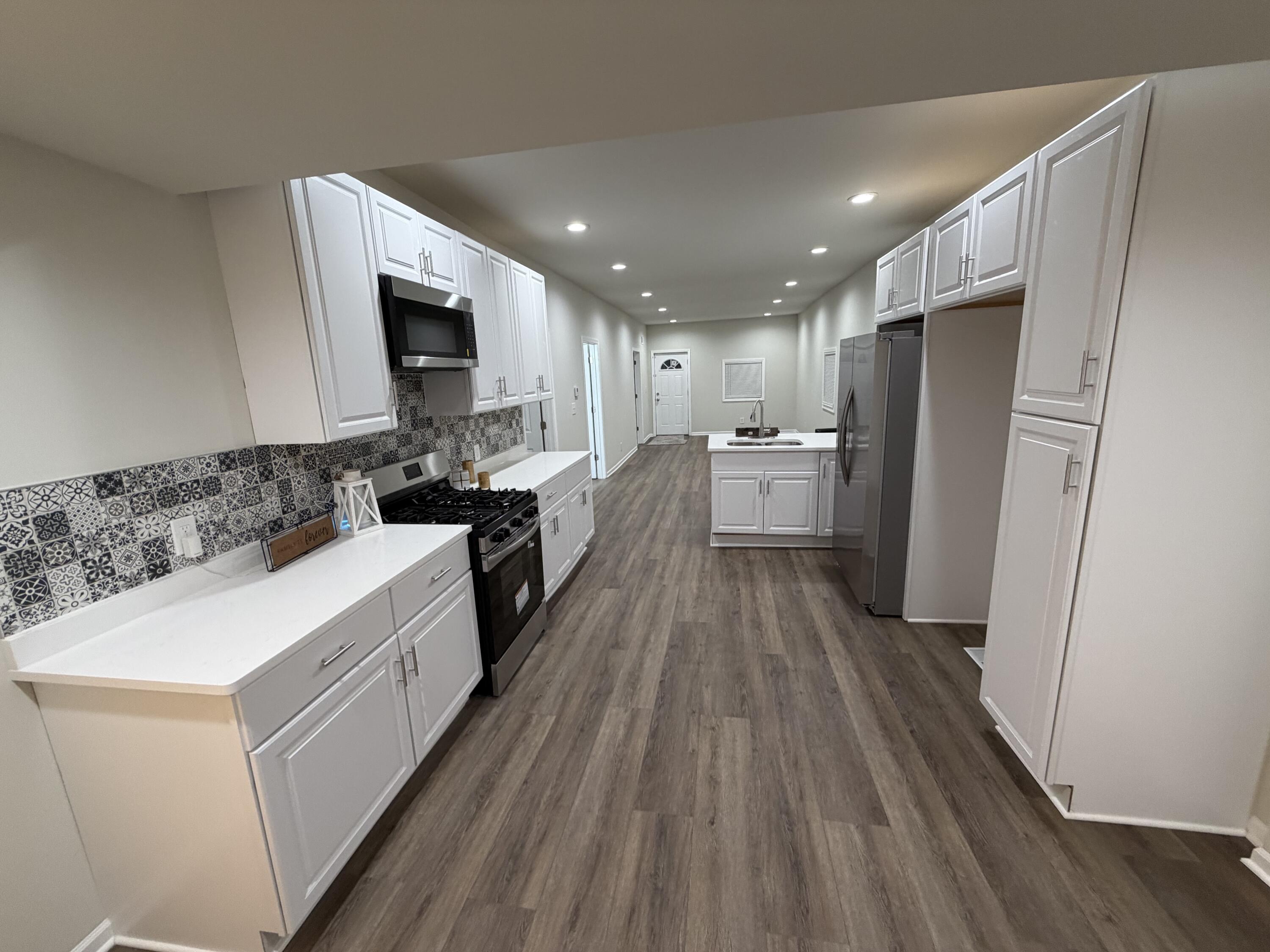 3744 Washington Street Gary, IN 46408 - Photo 6 of 25 a kitchen with a refrigerator a stove top oven and wooden floor