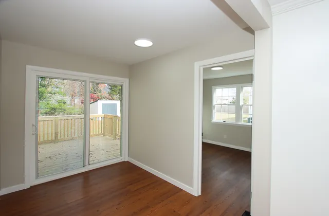 an empty room with wooden floor and a window