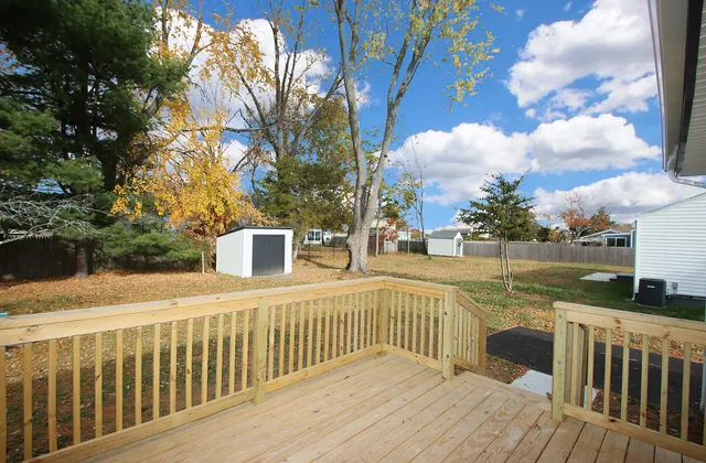 a view of a balcony with wooden floor and fence