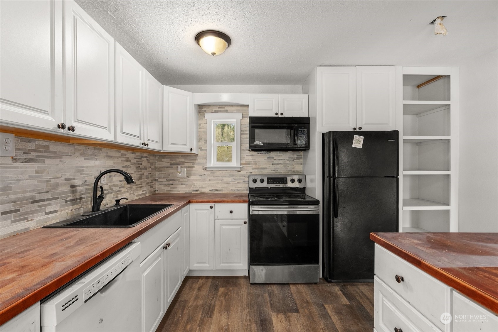 127 Remy Lane Chehalis, WA 98532 - Photo 8 of 24 a kitchen with a sink dishwasher a refrigerator and a stove with wooden floor