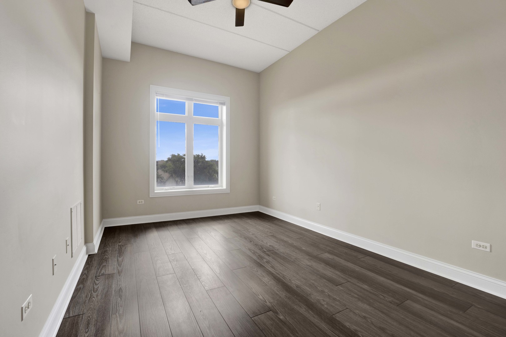 799 Graceland Avenue, Unit 504A Des Plaines, IL 60016 - Photo 22 of 25 a view of an empty room with wooden floor and a window