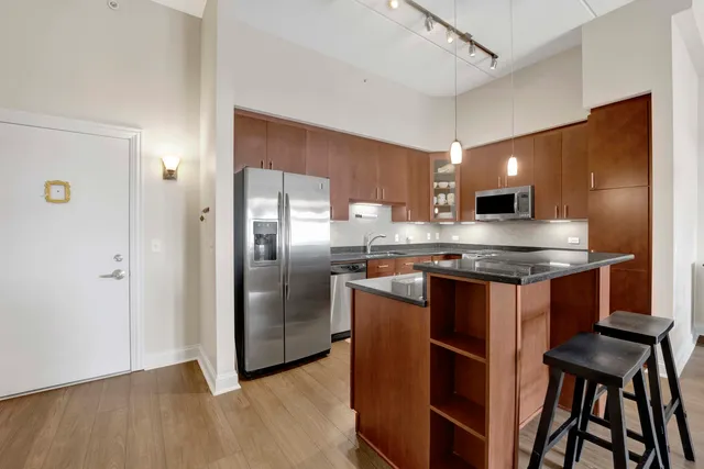a kitchen with kitchen island a counter top space cabinets and stainless steel appliances