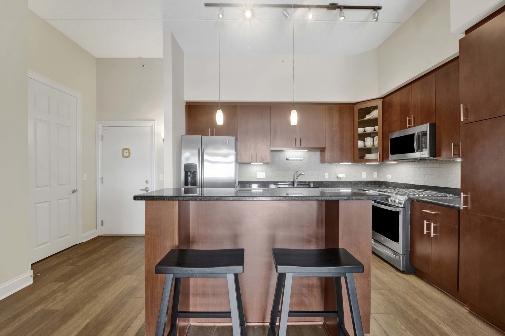 799 Graceland Avenue, Unit 504A Des Plaines, IL 60016 - Photo 7 of 25 a kitchen with stainless steel appliances kitchen island granite countertop a stove a sink and a microwave