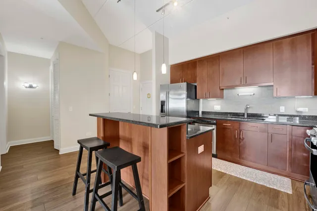 a kitchen with stainless steel appliances a refrigerator a sink a stove a microwave and wooden cabinets