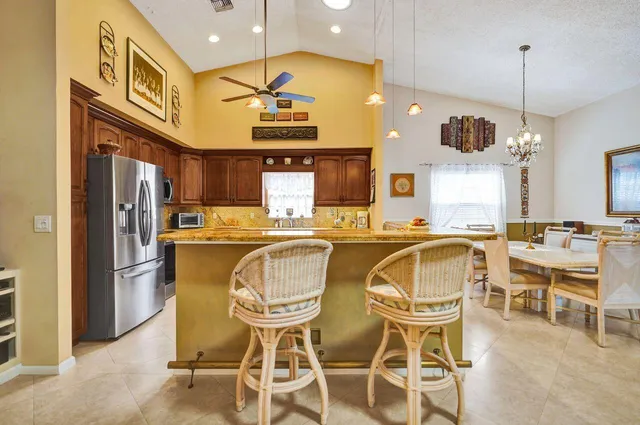 a kitchen with stainless steel appliances kitchen island granite countertop a refrigerator and a stove top oven