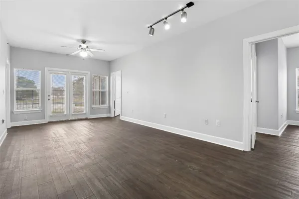 an empty room with wooden floor and windows