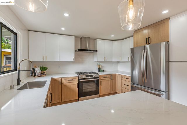 a kitchen with stainless steel appliances granite countertop a stove sink and refrigerator