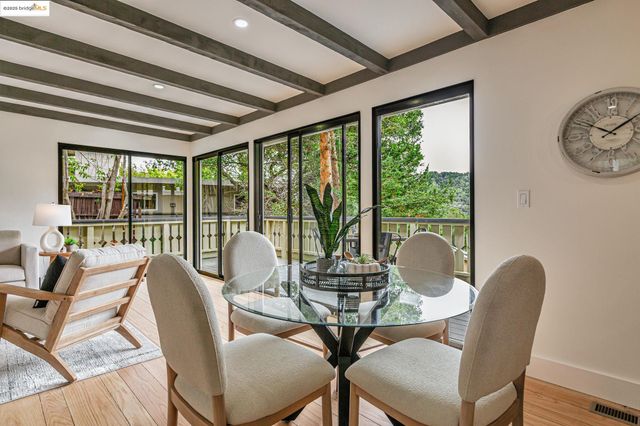 a dining room with furniture a chandelier and wooden floor