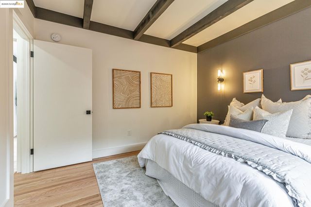 a spacious bedroom with a bed and a painting on the wall