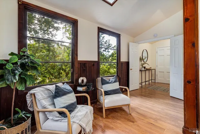 a living room with furniture a window and a potted plant
