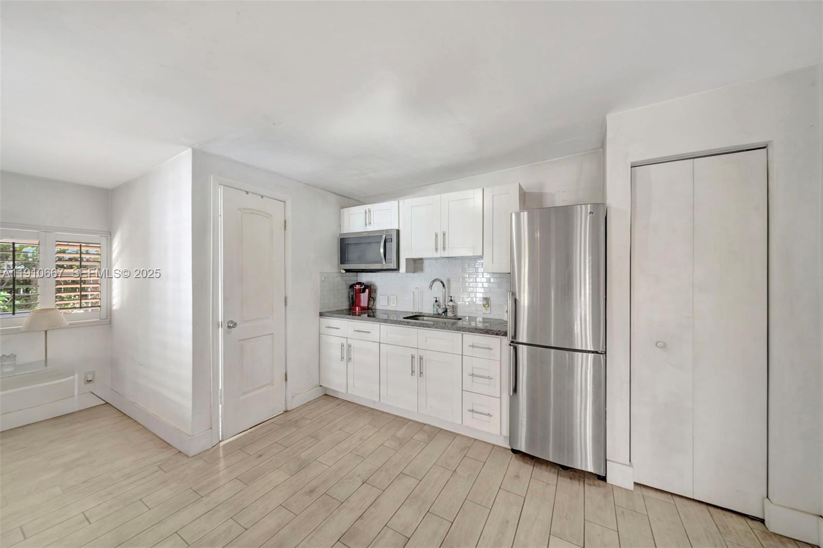 619 Northeast 87th Street Miami, FL 33138 - Photo 24 of 38 a kitchen with cabinets and wooden floor