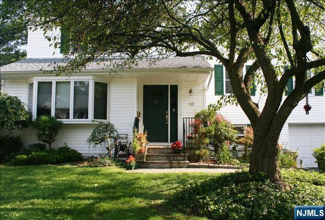 82 Heatherhill Road Cresskill, NJ 07626 - Photo 2 of 9 a front view of a house with a garden and a tree