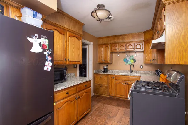 a kitchen with stainless steel appliances granite countertop a sink a stove and a refrigerator