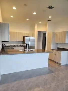 a living room with stainless steel appliances granite countertop furniture and a counter top space
