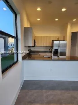 a living room with stainless steel appliances kitchen island granite countertop furniture and a flat screen tv