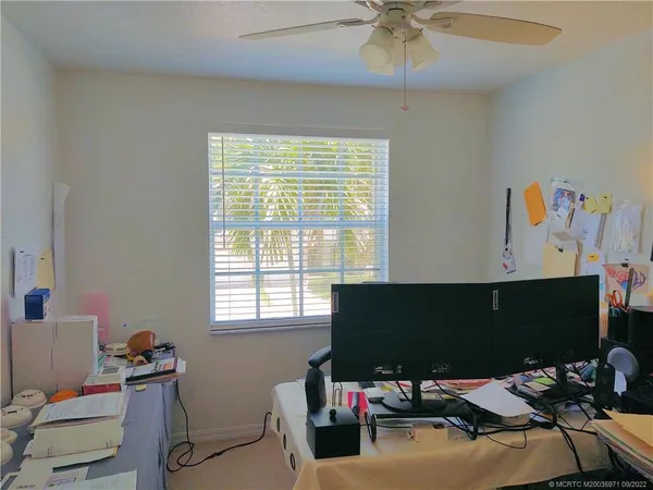 a view of a workspace with furniture and a window