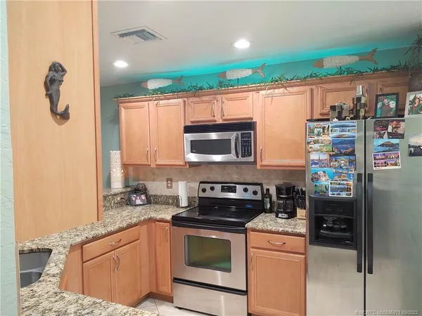 a kitchen with granite countertop a sink a counter space and cabinets