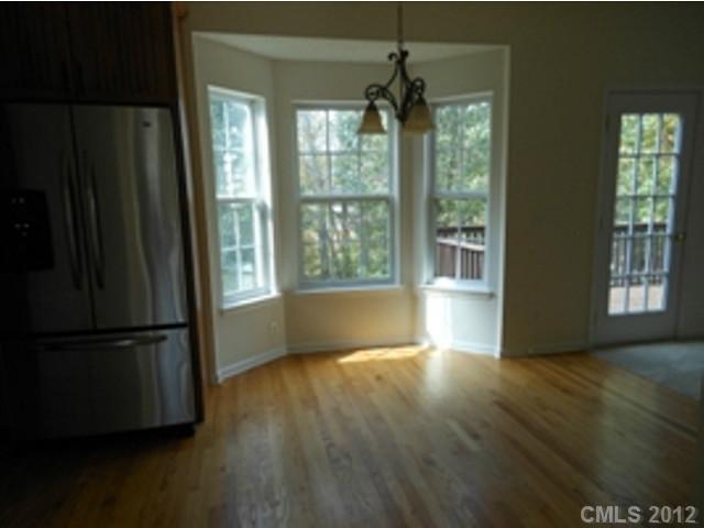 16023 Hollingbourne Road Huntersville, NC 28078 - Photo 6 of 12 a view of an empty room with wooden floor and a window
