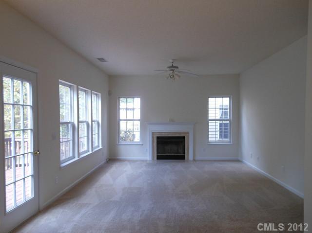 16023 Hollingbourne Road Huntersville, NC 28078 - Photo 7 of 12 a view of an empty room with a fireplace and a window