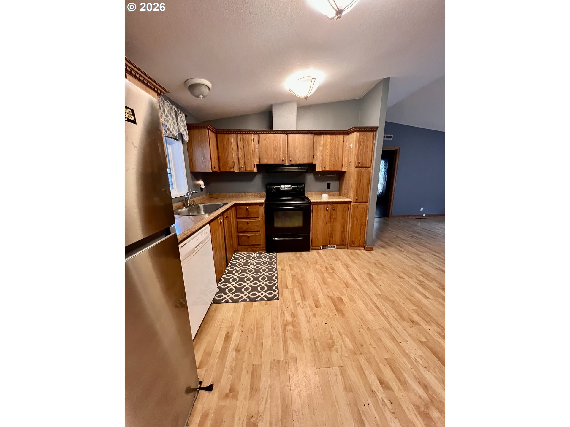 5200 Southeast 132nd Avenue, Unit 14 Portland, OR 97236 - Photo 7 of 17 a kitchen with kitchen island a counter top space a sink stainless steel appliances and cabinets