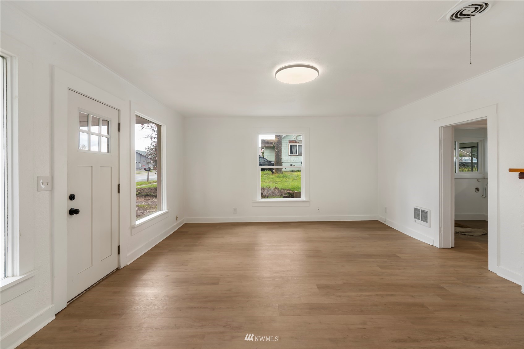 413 West 4th Avenue Pe Ell, WA 98572 - Photo 3 of 32 an empty room with wooden floor and windows