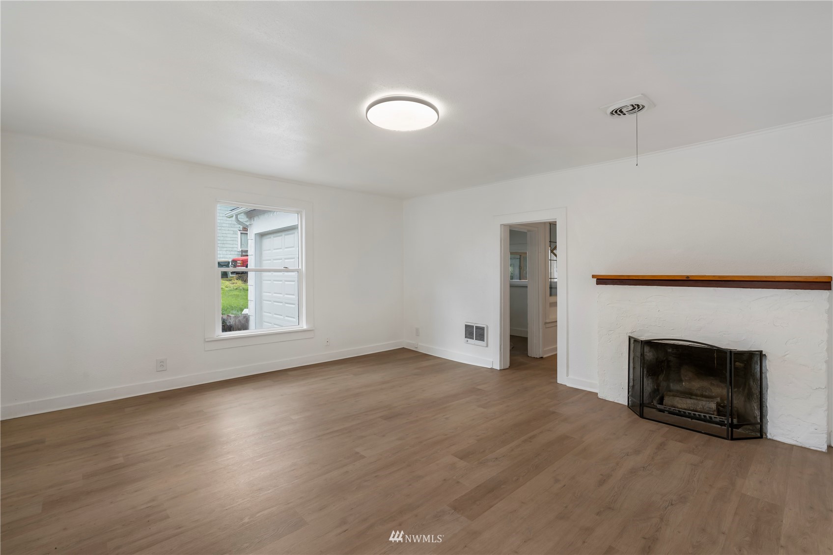 413 West 4th Avenue Pe Ell, WA 98572 - Photo 4 of 32 an empty room with windows and fireplace