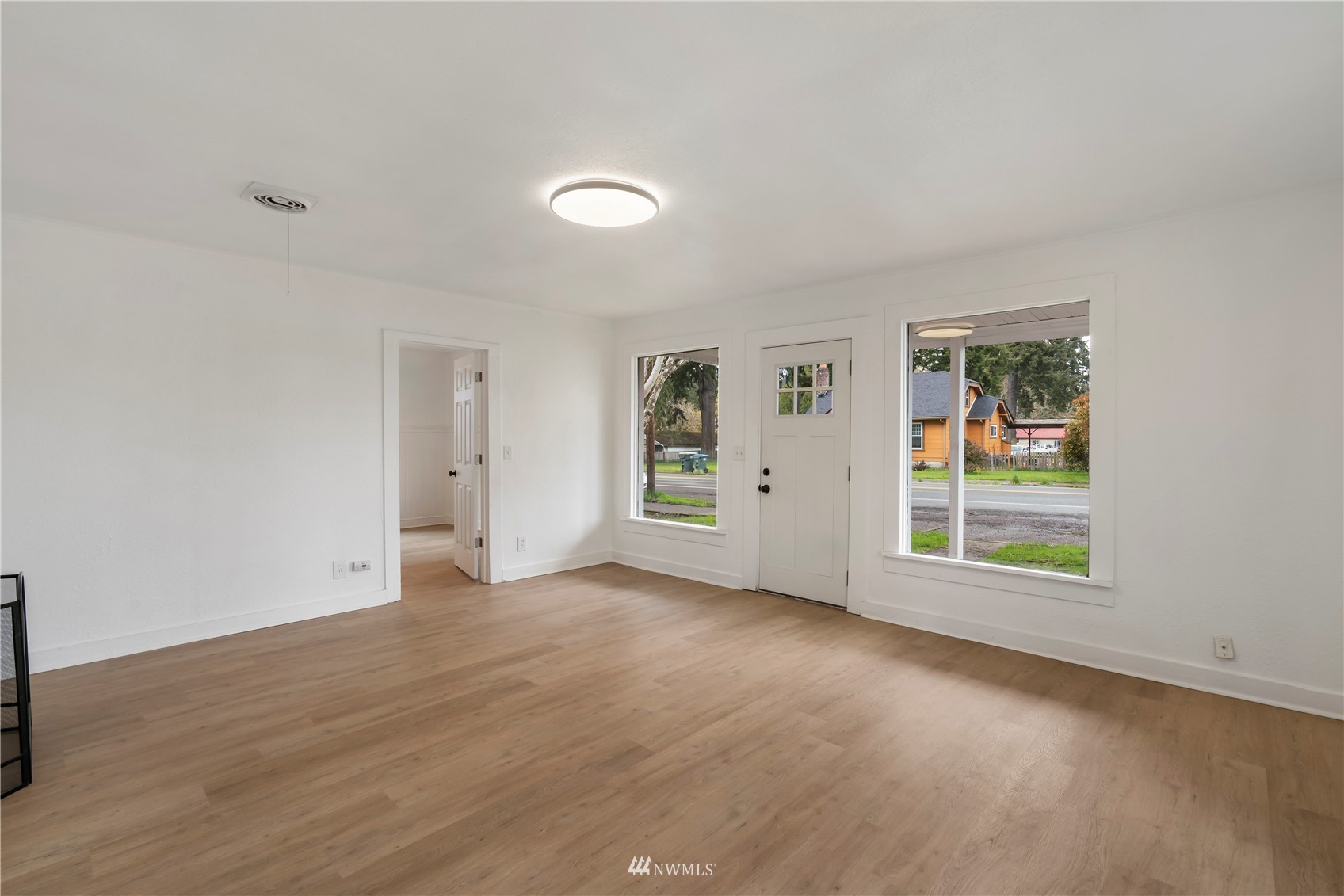 413 West 4th Avenue Pe Ell, WA 98572 - Photo 6 of 32 an empty room with wooden floor and windows