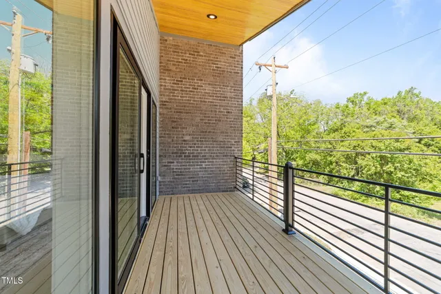 a view of a balcony with wooden floor and iron stairs