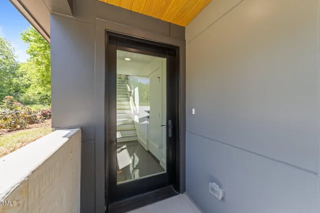 a view of hallway with a large window and wooden floor