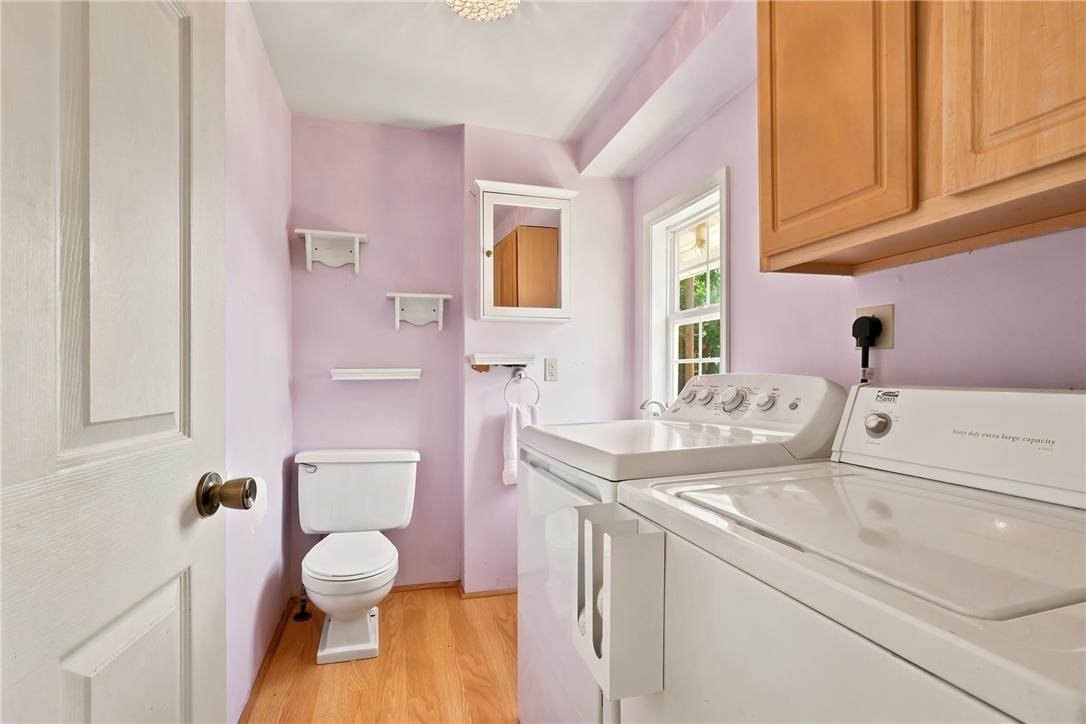 803 Spring Street Bethlehem, PA 18018 - Photo 14 of 34 A utilitarian laundry space features bright window light, hardwood flooring, and stacked machines for efficiency.