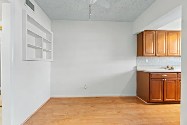 an empty room with windows and cabinet