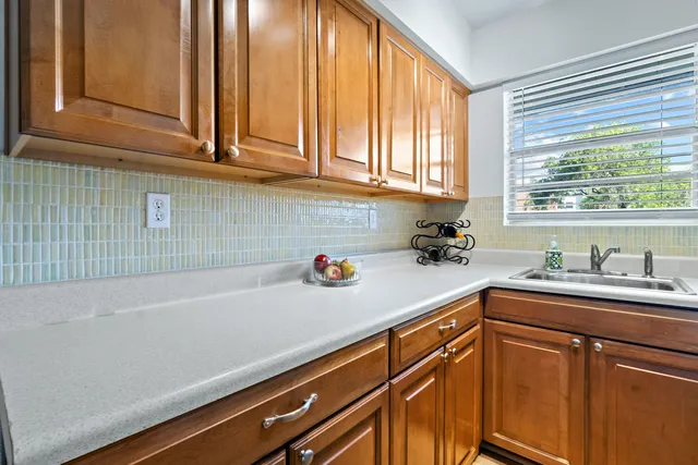 a kitchen with stainless steel appliances white cabinets a sink and a window