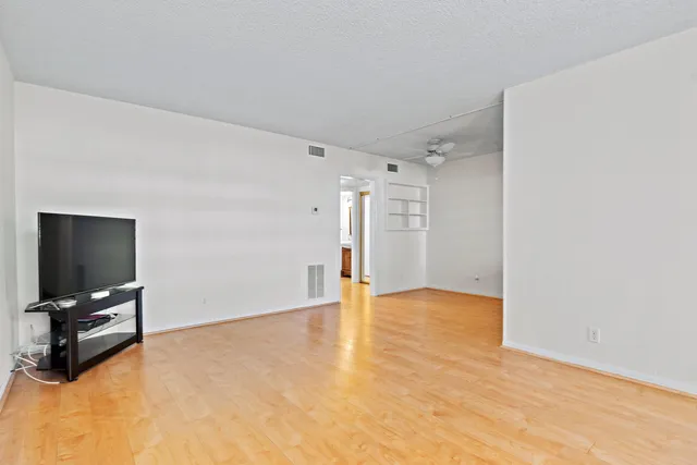 a view of an empty room with furniture and a flat screen tv