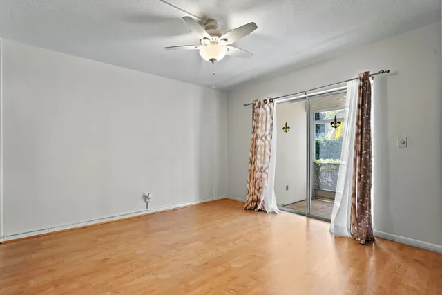 an empty room with closet and a ceiling fan