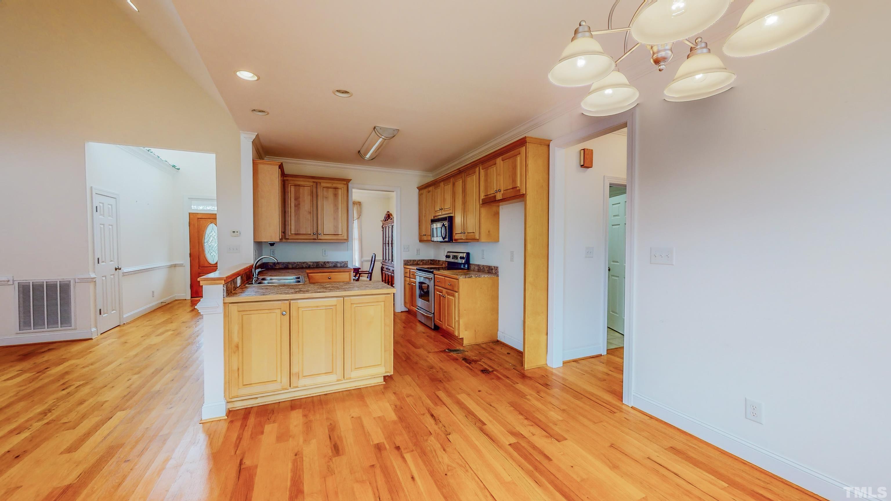 134 Fletcher Ridge Road Timberlake, NC 27583 - Photo 12 of 52 a view of a kitchen with kitchen island wooden floor center island and stainless steel appliances